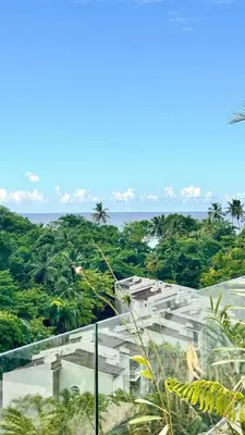 a building with trees and the ocean in the background at Casa Las Ballenas - 3 bedroom Las Terrenas in Las Terrenas