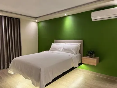 a green bedroom with a bed and a green wall at Caonabo35 Elegancia Boutique en Santo Domingo 5 in Santo Domingo