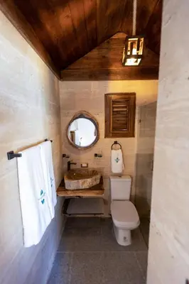 a bathroom with a toilet and a sink and a mirror at Serendipia Hotel Nizao in Nizao
