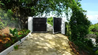two doors are open on a walkway near a fence at Endless Horizon Apartments in Las Terrenas