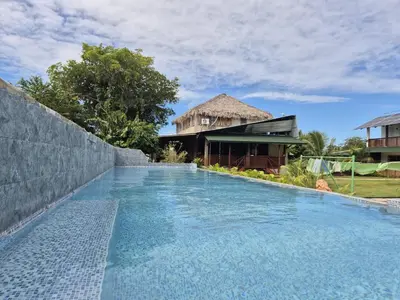 a swimming pool in front of a house at Dani's Guesthouse in Las Galeras