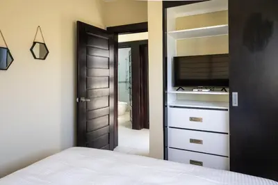 a bedroom with a bed and a dresser with a television at Newly built 2 bedroom 2 bath private pool villa! in Sosúa