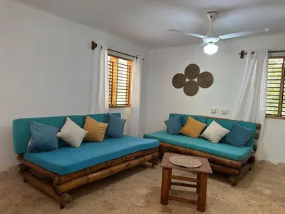 a living room with blue couches and a ceiling fan at Apartamento La Palmeras - 3 Pax, 5 Min de La Playa in Las Galeras