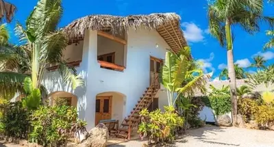 a large white house with a spiral staircase in front at Apartamento La Palmeras - 3 Pax, 5 Min de La Playa in Las Galeras