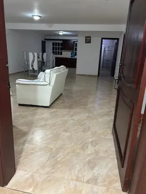 a living room with a white couch and a kitchen at Villas Burnette in Camú