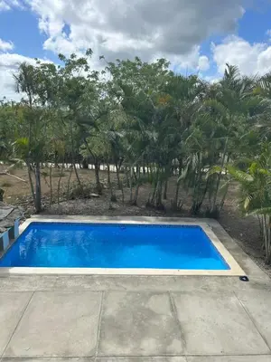 a blue swimming pool with trees in the background at Villas Burnette in Camú