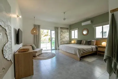 a bedroom with a bed and a living room at La Fenice 3 Bedroom Beachfront Apartment in Las Terrenas