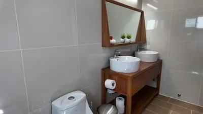 a bathroom with a sink and a mirror and a toilet at La Fenice 3 Bedroom Beachfront Apartment in Las Terrenas