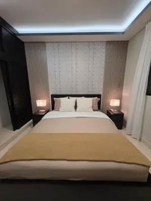 a bedroom with a large bed with two lamps at La Elegancia in Canabacoa