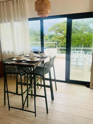 a dining room table and chairs with a view of a balcony at MeliT in Las Terrenas