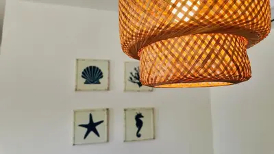 a chandelier hanging from a wall with pictures on it at MeliT in Las Terrenas