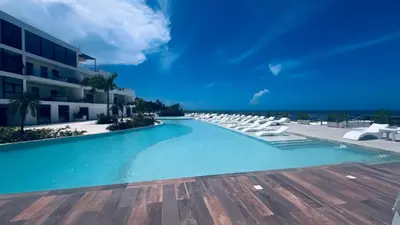 a swimming pool with lounge chairs and a building at MeliT in Las Terrenas