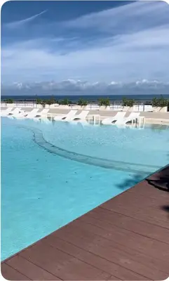 a swimming pool with blue water in front of a beach at MeliT in Las Terrenas