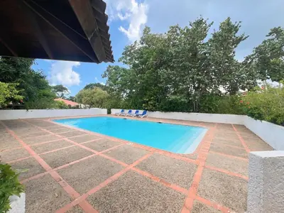 a swimming pool with blue water in a yard at Private Suite in Casa de Campo in La Romana