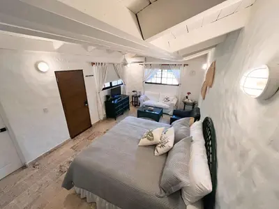 a bedroom with a bed and a living room at Private Suite in Casa de Campo in La Romana