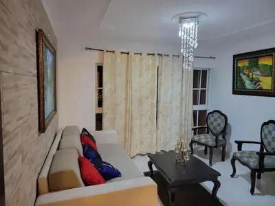 a living room with a couch and a chandelier at Apartamento Confortable Moderno Minimalista in Ciruelitos Arriba