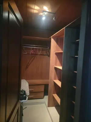 a walk in closet with wooden cabinets and a light at Apartamento Confortable Moderno Minimalista in Ciruelitos Arriba