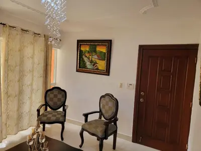 two chairs in a living room with a chandelier at Apartamento Confortable Moderno Minimalista in Ciruelitos Arriba