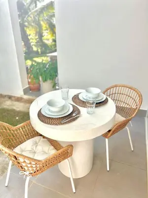 a white table with two chairs and a table with plates and cups at Beachside Studio with Pool, Steps to Playa Bonita in Las Terrenas