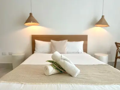 a bedroom with a white bed with two lamps at Beachside Studio with Pool, Steps to Playa Bonita in Las Terrenas