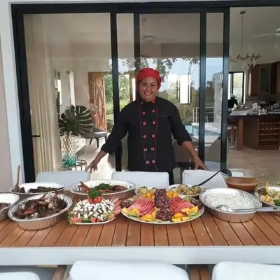 a woman standing in front of a table of food at Space Freedom Connection in Sosúa