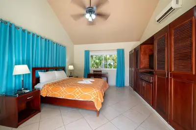 a bedroom with a bed with blue curtains and a window at Space Freedom Connection in Sosúa