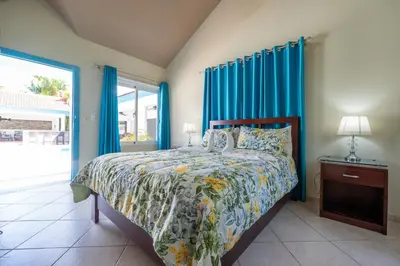 a bedroom with a bed with blue curtains at Space Freedom Connection in Sosúa