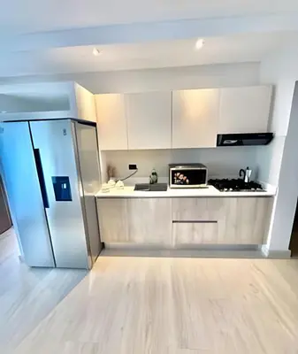 a kitchen with white cabinets and a stainless steel refrigerator at Garden Breeze 1 By Advantage Club