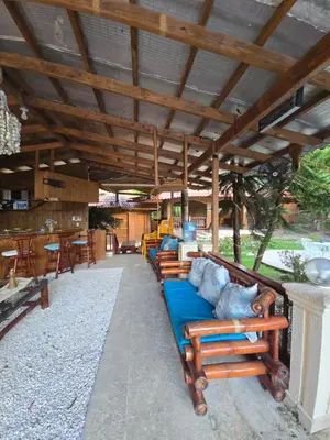 a group of wooden benches sitting under a roof at Villa Doña Macha