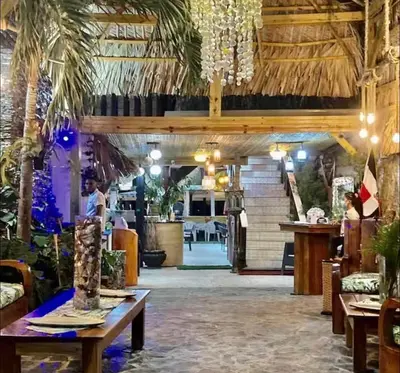 a restaurant with palm trees and a dining room at WRparaiso in Boca Chica