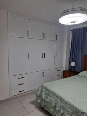 a bedroom with white cabinets and a bed at Torre san geronimo 1109 apartamento 10-06 in Santo Domingo