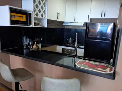 a kitchen with a black counter top with a refrigerator at Torre san geronimo 1109 apartamento 10-06 in Santo Domingo
