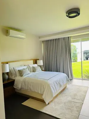 a bedroom with a bed and a large window at Villa Paraíso Casa de Campo in La Romana
