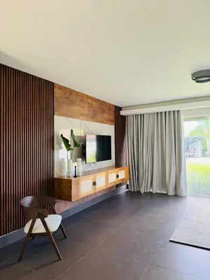 a living room with a television and a chair at Villa Paraíso Casa de Campo in La Romana