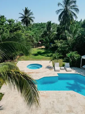 a swimming pool in a yard with palm trees at Lux Villa Casa de Campo in La Romana