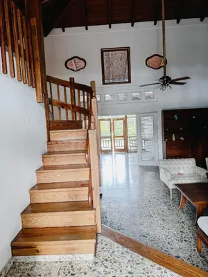a wooden staircase in a living room with a couch at Lux Villa Casa de Campo in La Romana