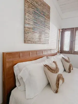 a bed with white pillows and a wooden head board at Lux Villa Casa de Campo in La Romana