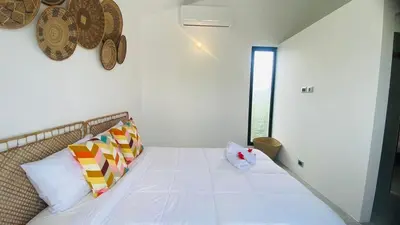 a bedroom with a large white bed with colorful pillows at Private Pool Villa With Parking in Las Terrenas