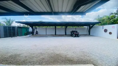 a large garage with a motorcycle parked under a roof at Private Pool Villa With Parking in Las Terrenas