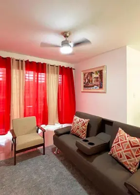 a living room with a couch and red curtains at Apartment near the airport in Boca Chica