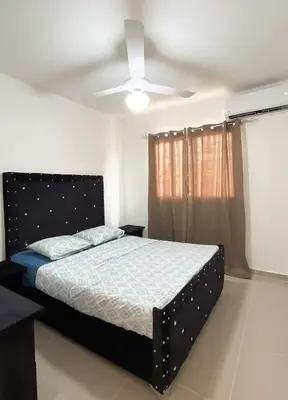 a bedroom with a bed and a ceiling fan at Apartment near the airport in Boca Chica