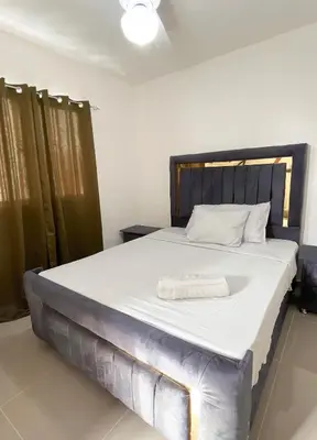 a bedroom with a large bed with a wooden headboard at Apartment near the airport in Boca Chica
