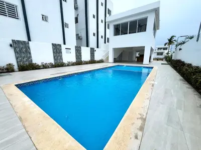 a swimming pool in front of a building at Ideal space for the family in Boca Chica