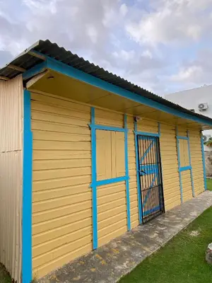 a yellow and blue shed with blue doors at the Count of Villa Rosa in La Ceiba