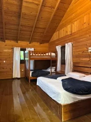 a bedroom with two beds in a wooden cabin at Blue Lagoon House RD