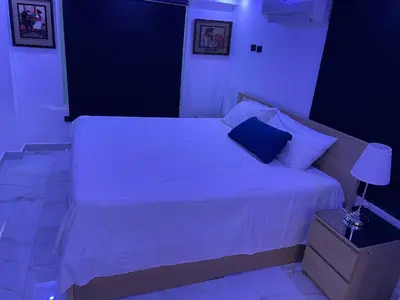 a bedroom with a white bed with a blue pillow at Bella casa en lo alto in El Seis