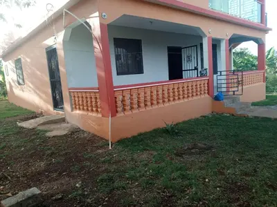 a small house with a porch and a yard at Casa Ramona in Las Galeras