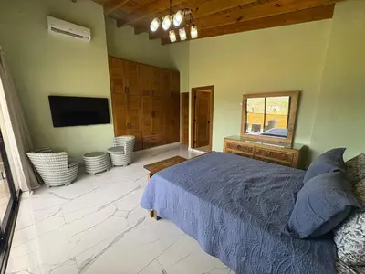 a bedroom with a bed and a flat screen tv at Villa Sol Odalis in Jarabacoa