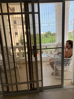a woman sitting in a chair talking on a cell phone at Apartamento en Gribi in Juan Dolio