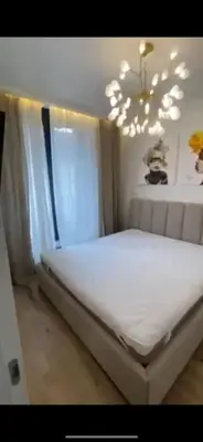 a bedroom with a white bed with a chandelier at Sirius apartment in Santo Domingo